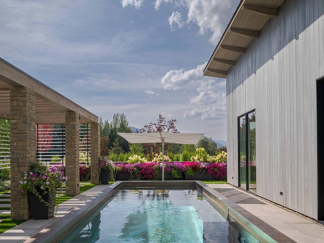 This modern barn-inspired mountain home features timeless materials like Montana sandstone and white oak, combining clean Scandinavian lines with subtle Southern detailing.