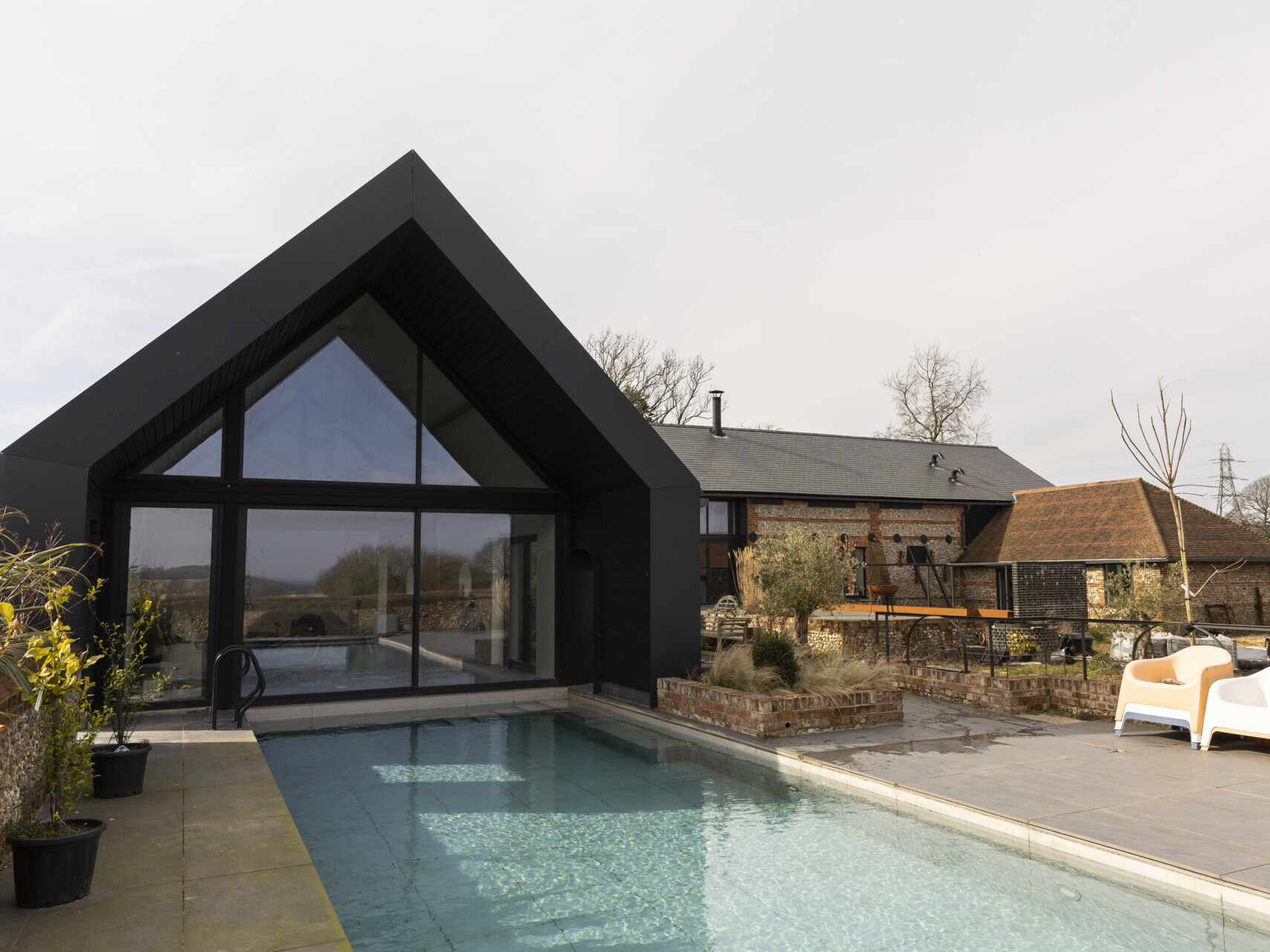 A collapsing dairy barn has been reimagined as a modern family home blending rustic charm with bold, contemporary design.