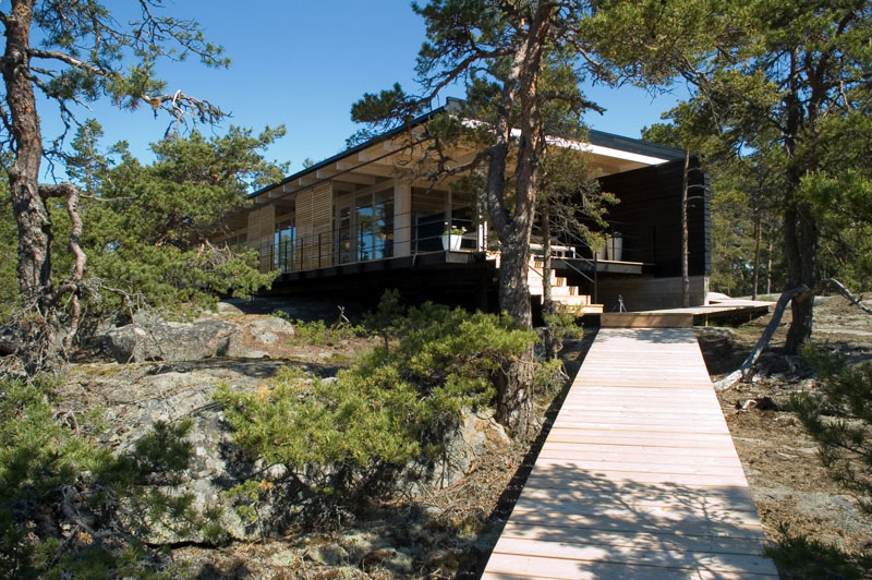 A low-lying cabin in the Finnish archipelago sits on rocky terrain with sweeping views of the sea. Built from Finnish timber with prefabricated modular parts, the cabin combines simplicity with lasting quality.
