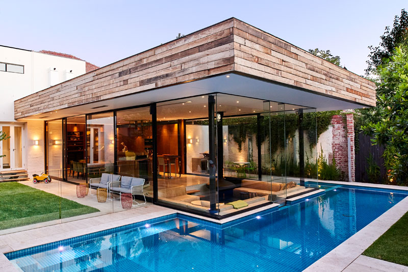 A sleek lap pool and spa features an acrylic panel that connects the water to the sunken lounge inside.
