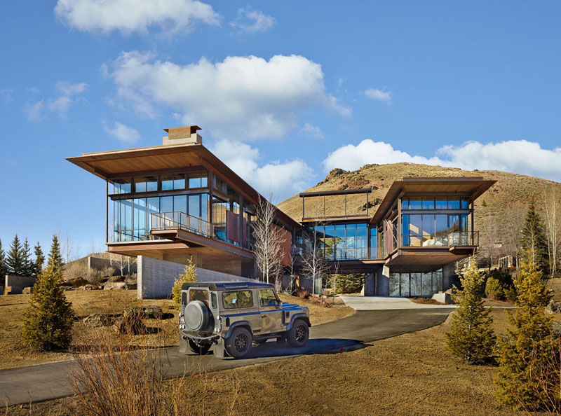 A modern industrial house in Idaho designed with steel, glass, and board-formed concrete, seamlessly blending into the mountain landscape while opening to breathtaking views.