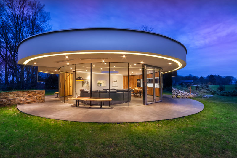 Tucked into a hillside, this home’s circular shape minimizes its footprint and blends seamlessly into the forest. Circular windows wrap around half the house, while mirrored walls at each end create the illusion of endless glass. 