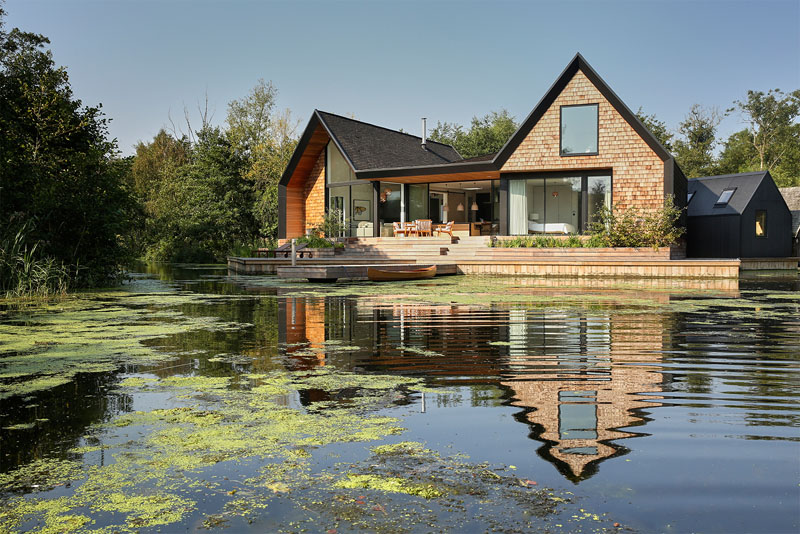 A modern family home with pitched roofs and black-stained shingles designed to echo traditional boat sheds along the Norfolk Broads.