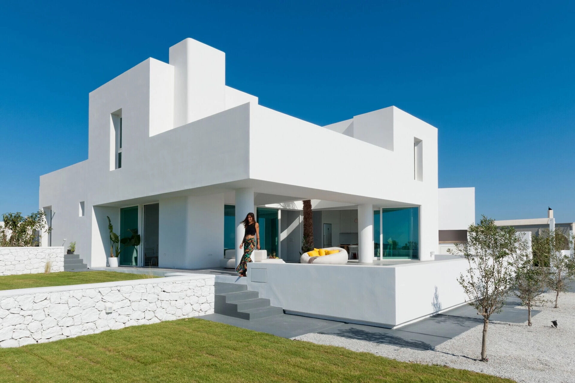 A striking example of modern Greek island design, this Santorini summer house by Kapsimalis Architects reinterprets traditional cubist architecture with clean lines, open volumes, and a serene palette of white and grey.