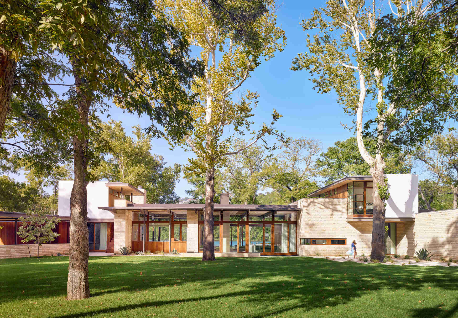 This Lake Austin home by A Parallel Architecture is a masterclass in lakeside modernism, blending limestone, wood, and glass in a form that seems to float above the water.