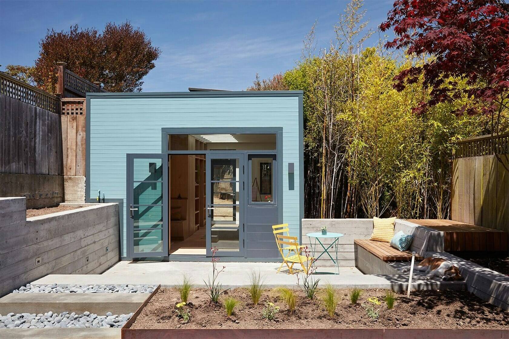 Once a simple garage, this backyard studio now serves as a creative workspace, complete with a reading niche, powder room, and bookshelves.