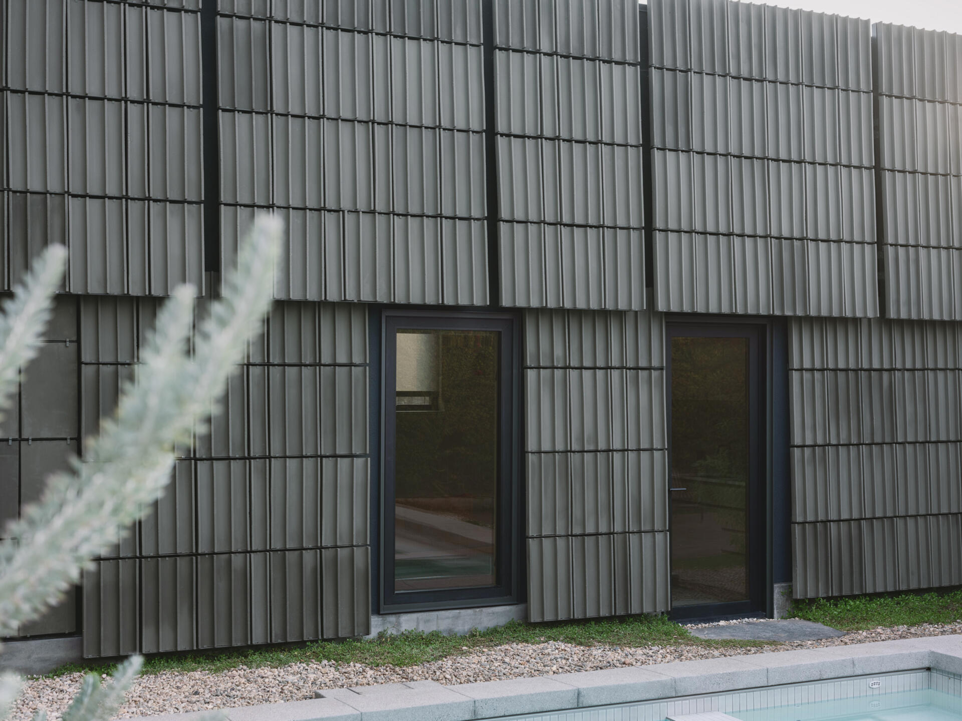 A Los Angeles ADU wrapped in green terracotta tiles transforms a forgotten backyard into an architectural statement, celebrating material craft and the beauty of shadow and texture.