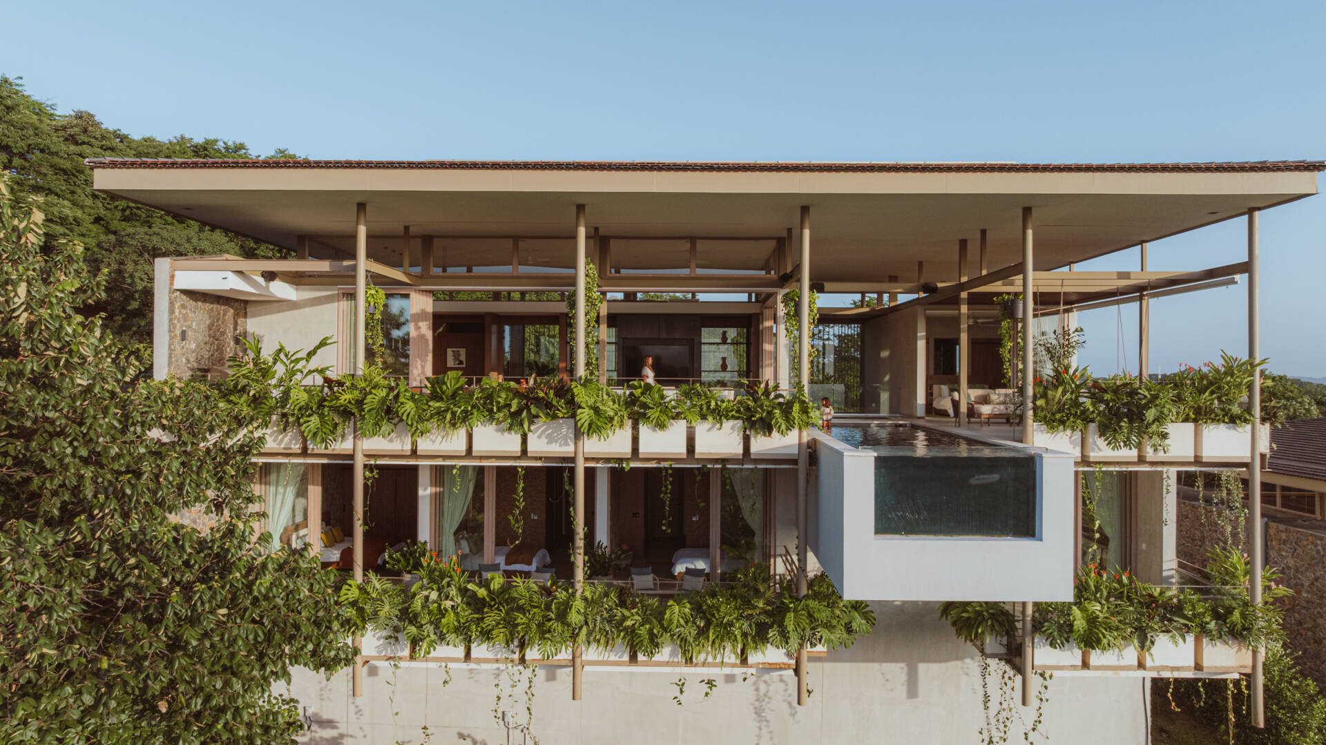 A hillside villa in Costa Rica with a cantilevered swimming pool, is shaped by terraces and light, designed for calm indoor and outdoor living.