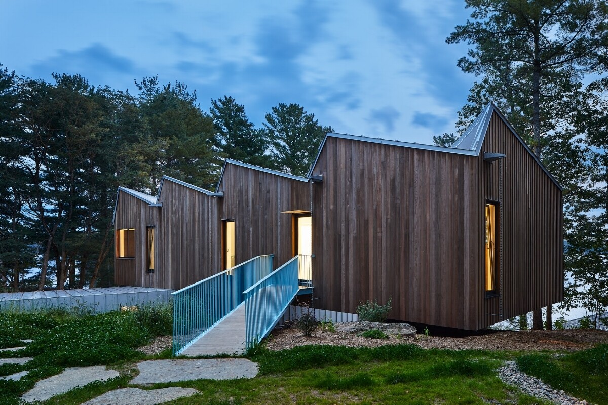 A striking lakeside home in Ontario that balances bold design with nature. Sky House seems to float above the ground, its upper volume cantilevered over the lower, blending modern form with natural beauty.