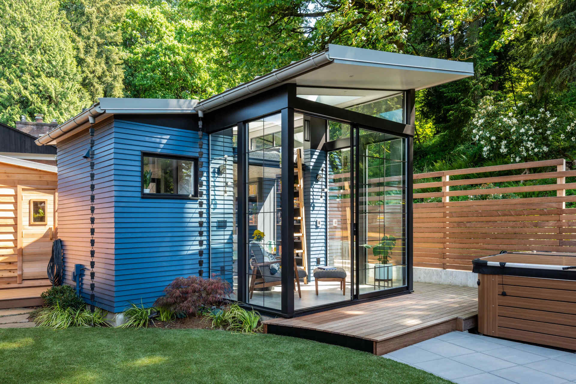 This backyard reading shed by Board & Vellum blends quiet comfort with smart design, featuring a loft bed, skylights, built-in seating, a bathroom, and a wallpapered ceiling that hides integrated speakers.