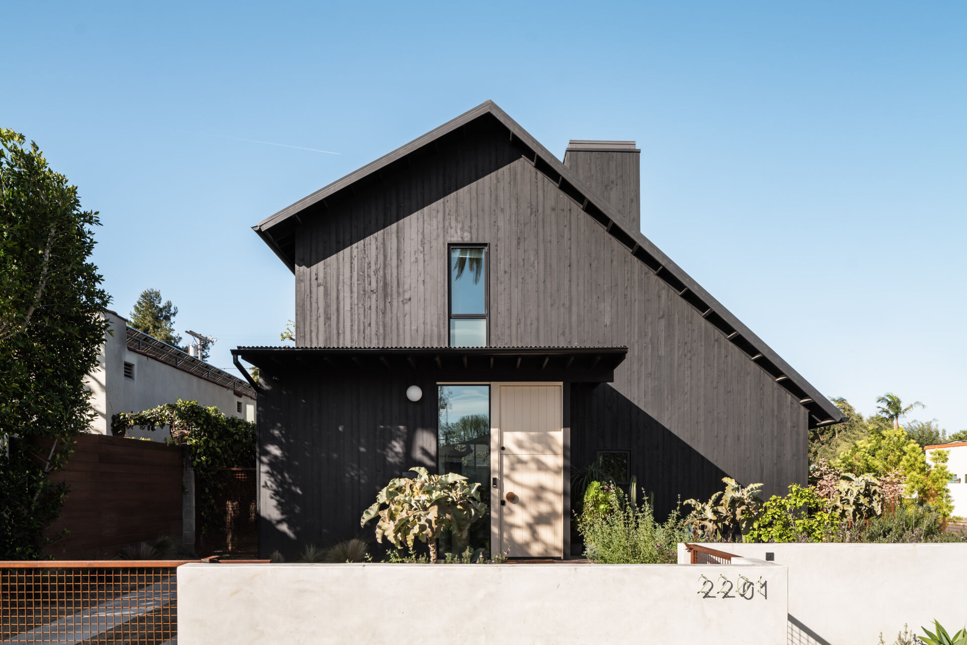 A modern home with an exaggerated gable roof also has an ADU.