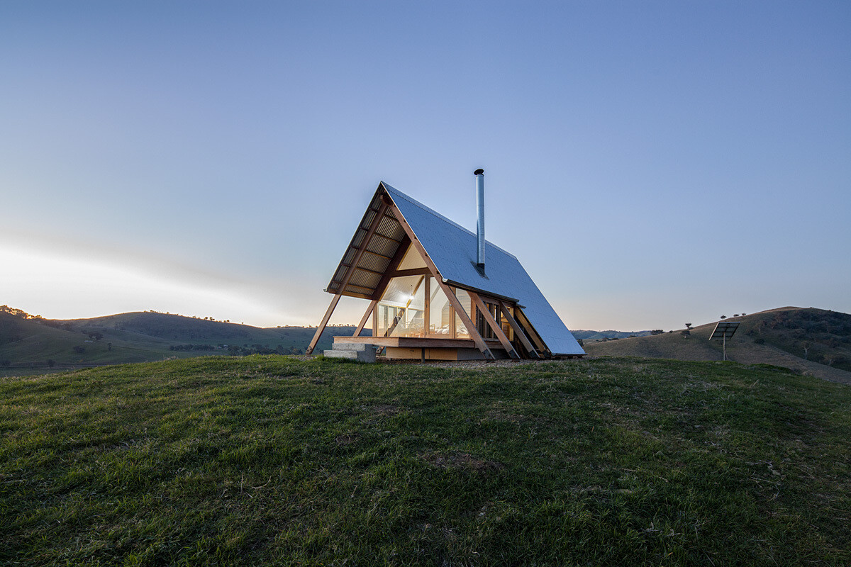 JR’s Hut is a small timber cabin on Kimo Estate in rural New South Wales. Inspired by a classic ‘A’ frame, it’s designed for relaxation, featuring sustainable hardwoods, a cozy interior, and views over the surrounding farmland.