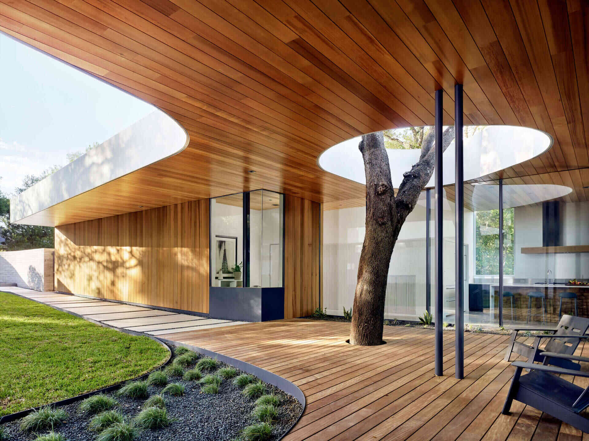 This Austin home begins with a front patio designed around a live oak tree, allowing nature to pass directly through the architecture.