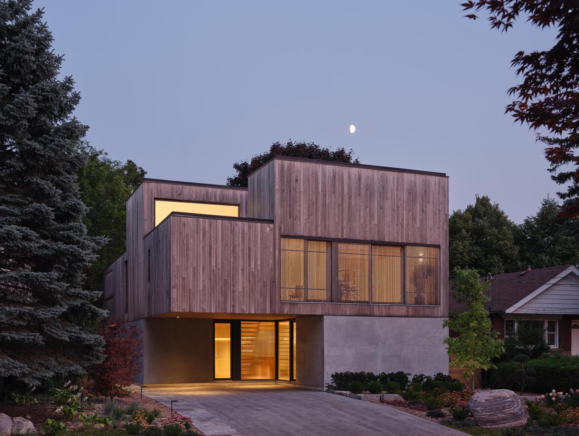 Concrete and wood volumes intersect to create layered interiors of this modern house.