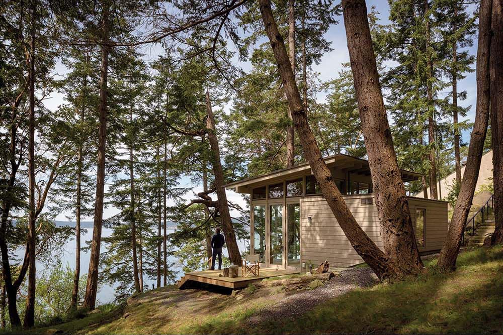A one room cabin interior designed as a flexible studio or guesthouse with an open layout and minimal structure